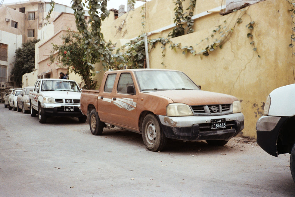 Pickup trucks parked next to a beige wall