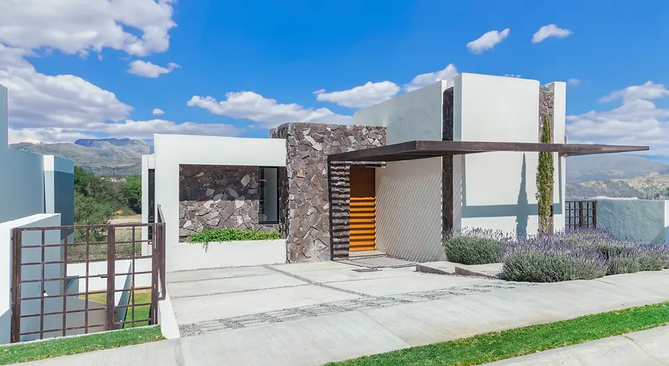 Fachada Casa Santa Catalina, acabado en piedra con celosia de acero y puerta principal de madera