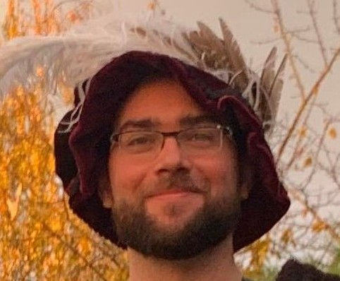 tête de jeune homme portant une faluche 16e siècle en velours rouge avec plumes blanches