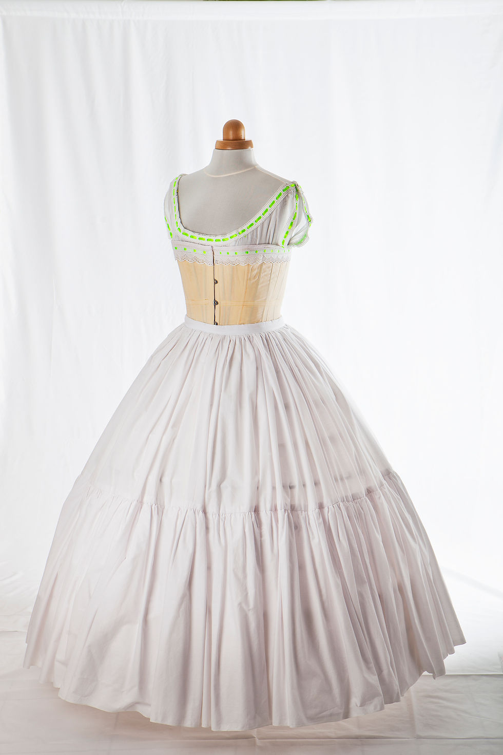 Sous vêtements 19ème siècle - chemise, corset, jupon, crinoline) beige et blanc à rubans verts, vue de 3/4 face