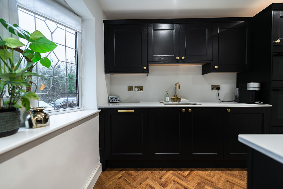 Carbon shaker kitchen cabinetry with white quartz worktops and integrated appliances.