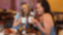 Women eating breakfast, plate of eggs, potatoes and sausage, and sauce being poured over French toast