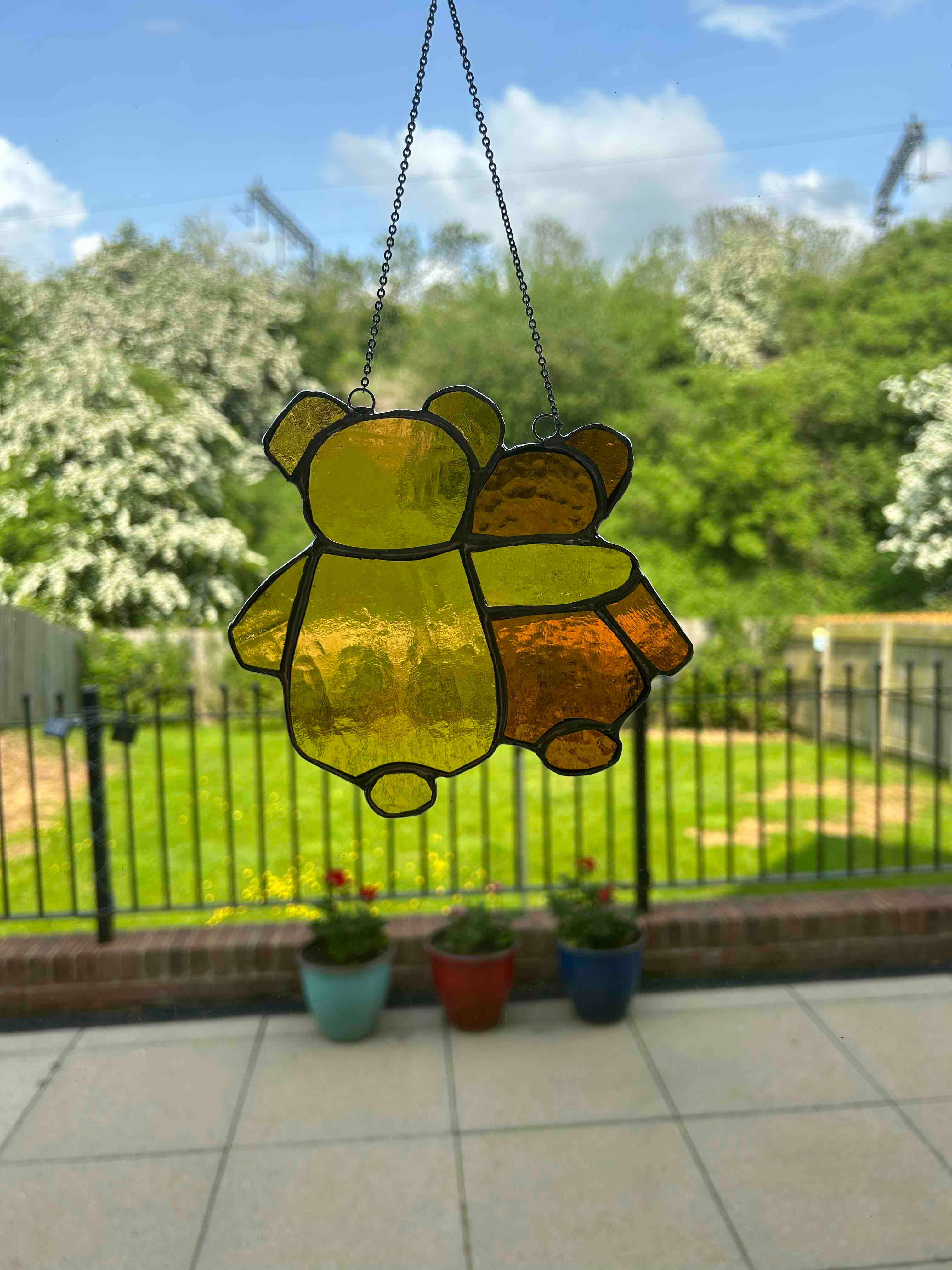 Big yellow bear hugging small brown bear looking away