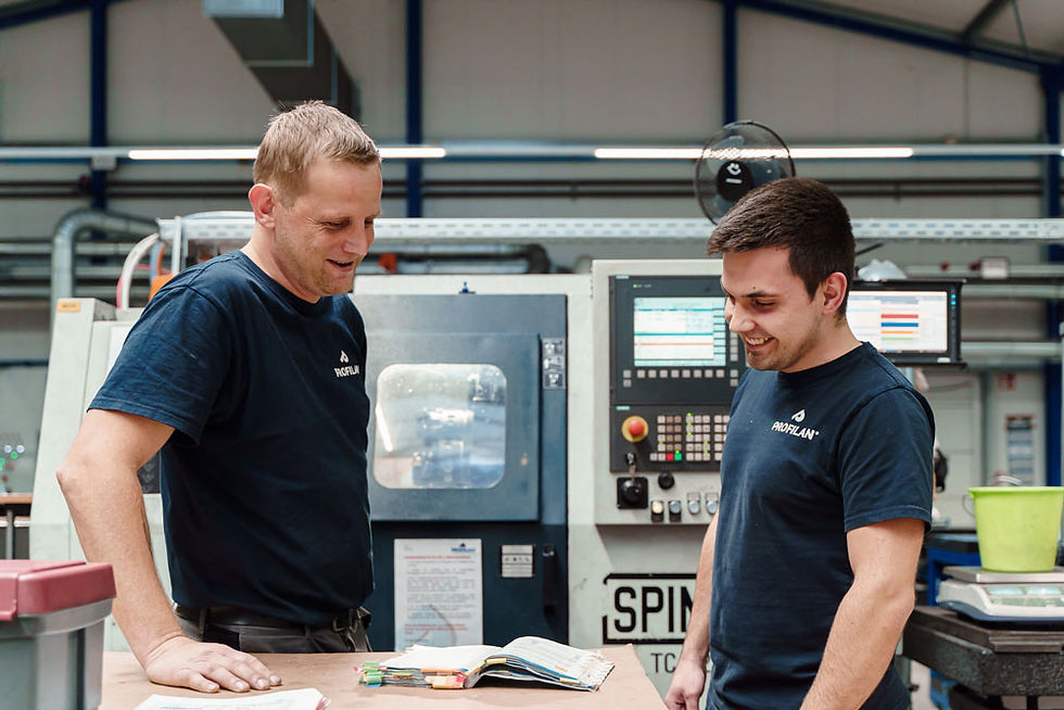 Two technicians discuss plans on CNC milling machine