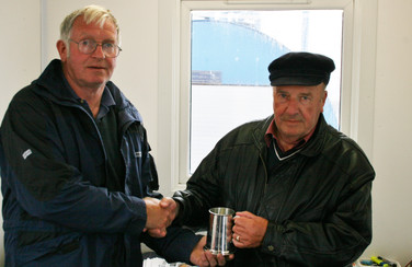 Commodore John Abernethy presents former Commodore John Lowrie Simpson with his service tankard.