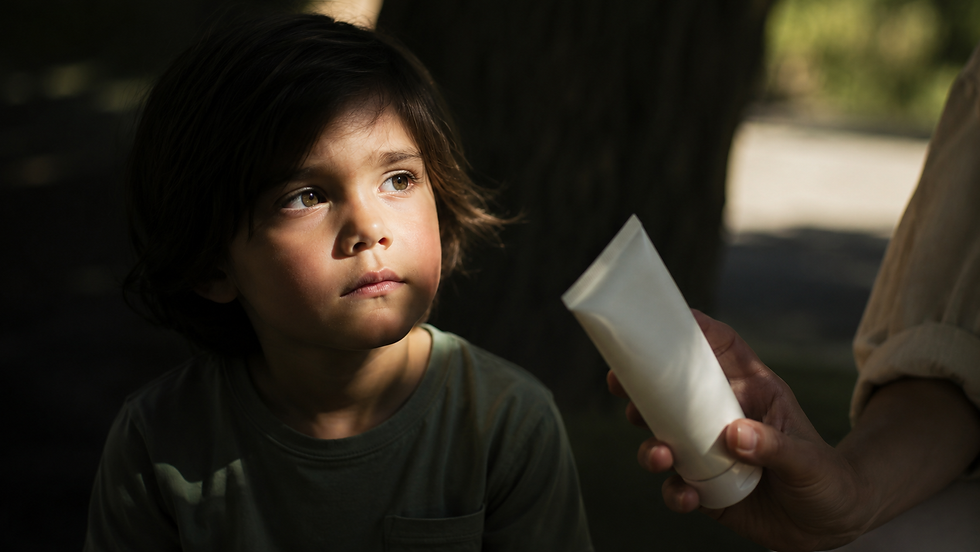 Child sitting in partial shadow while an adult holds a plain sunscreen tube, symbolising lack of transparency in children’s sunscreen marketing.