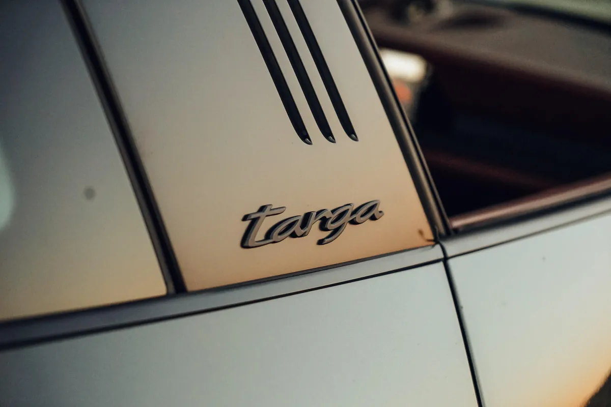 Close-up of classic Targa badge at sunset.