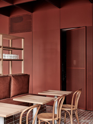 Coin banquette et murs en métal rouge brique dans le café Bentwood à Melbourne.