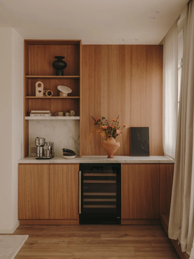 Kitchen of Arcadia by Santa Living and MA&Partners, with wooden cabinetry, marble countertop, terracotta vase and light curtains.