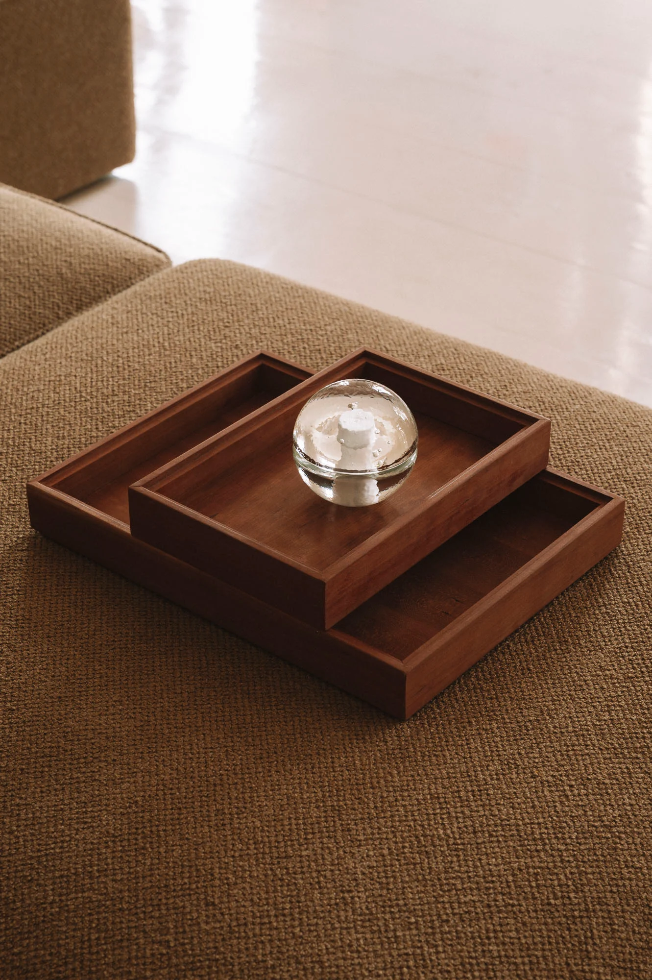 Plateaux en bois et objet en verre sur textile, détail design intérieur - Karst Berlin.