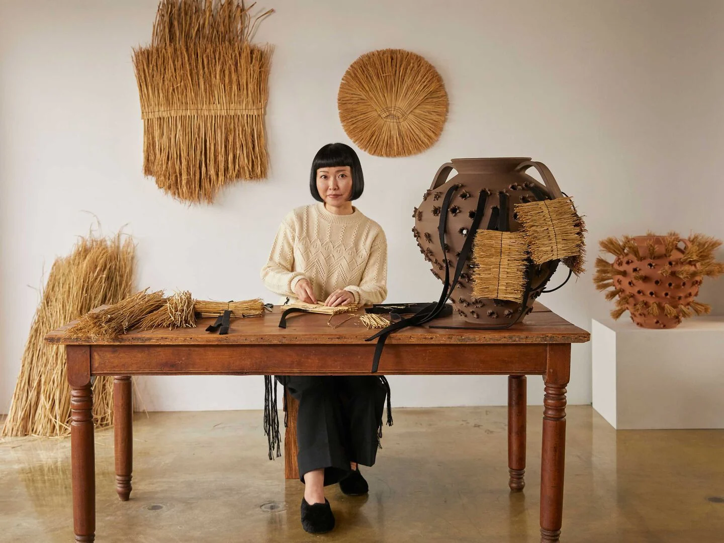Artisan creating a straw and ceramic piece for Loewe Craftsmanship.