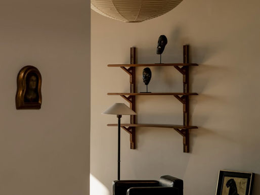 Minimalist living room with black armchair and wall shelves at Somerset House, interior photography by Austin John.