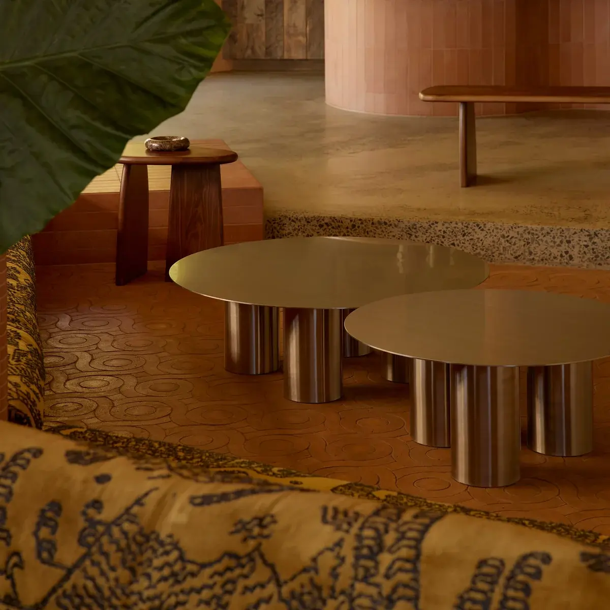 Tables basses métalliques de la Oslo Collection par Fleur Studios dans un intérieur aux tons terre.
