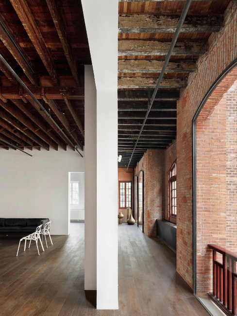Intérieur du Design Republic Design Commune par Neri&Hu, avec poutres en bois, brique et mobilier contemporain.