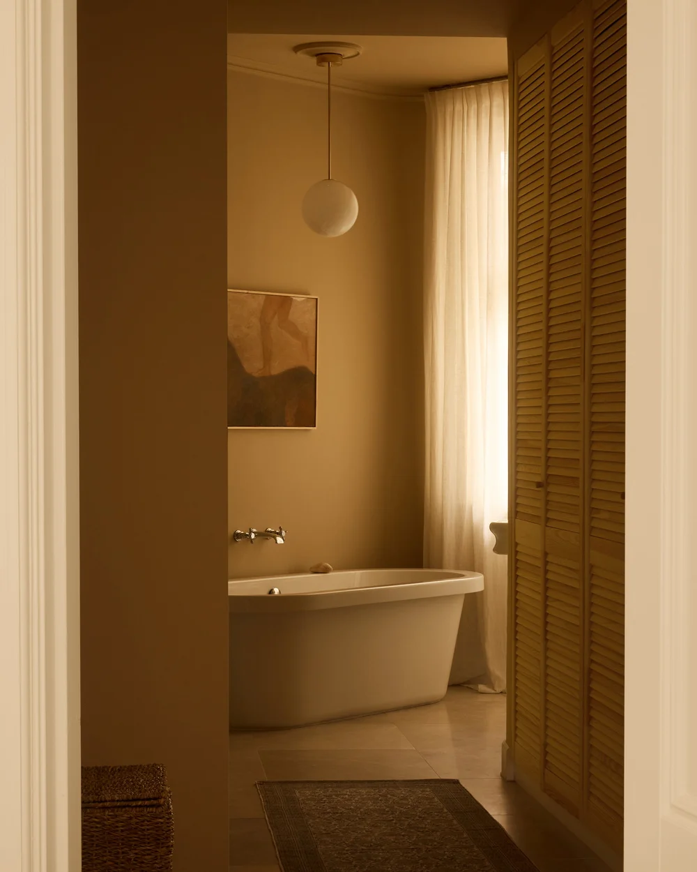 Salle de bain avec baignoire, rideau clair et lumière douce dans le projet De Baarsjes par Bob Van Zonneveld.