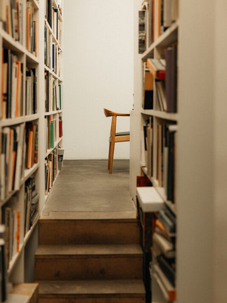 Architectural photography by Maureen M. Evans for Architectural Digest — library shelves framing a single wooden chair.