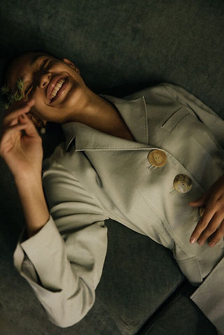 Fashion portrait by Maureen M. Evans for Rejina Pyo — woman smiling in soft light, minimalist editorial style.