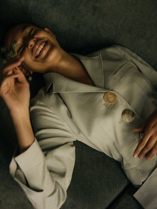 Fashion portrait by Maureen M. Evans for Rejina Pyo — woman smiling in soft light, minimalist editorial style.