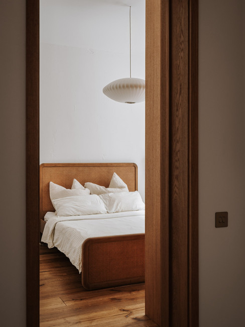 Chambre contemporaine à Notting Hill par Ola Jachymiak, avec lit en cannage, bois chaleureux et lumière douce.