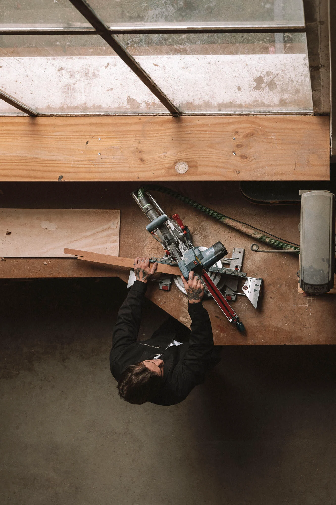 Artisan travaillant le bois en atelier, menuiserie design intérieur - Karst Berlin.