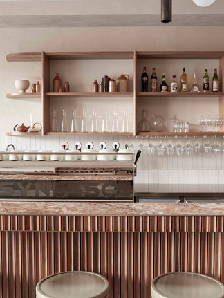Comptoir en marbre et étagères en bois clair du café Via Porta à Melbourne.