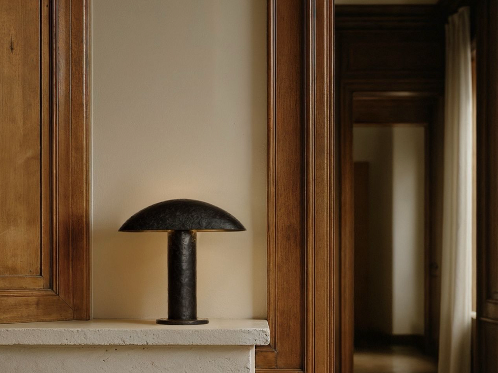 Lampe à poser Nezu étain petit modèle par Garnier & Linker, lumière architecturale sur manteau de cheminée en bois.