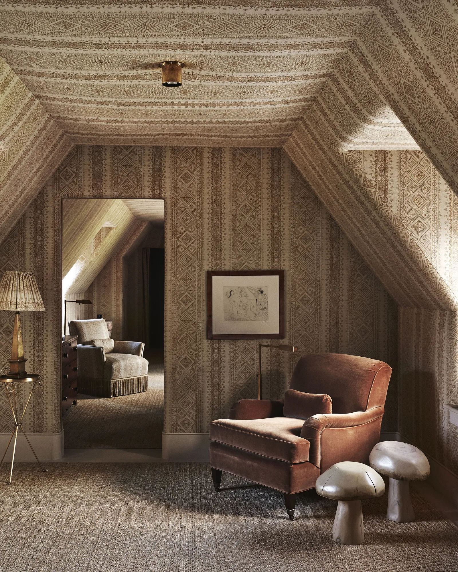 Chambre mansardée, fauteuil en velours brun et motifs textiles ton sur ton.