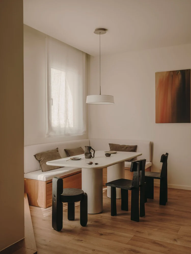 Dining room of Arcadia by Santa Living and MA&Partners, with a white table, black chairs, light banquette and translucent curtain.