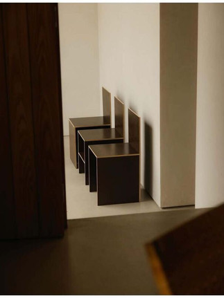 Minimalist interior detail of John Pawson’s home by Maureen M. Evans for Architectural Digest — wooden chairs aligned in light.
