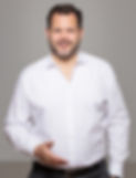 Tim von Törne lächelt und hält die Hand aus