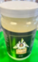 Close-up view of a jar filled with golden sea moss gel on a wooden table