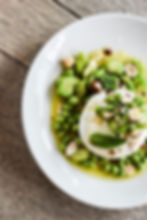 Plat de cuisine saine : burrata, pois verts, fèves et noisettes.