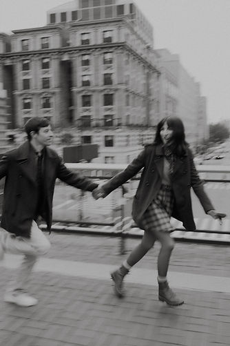 A black and white photo of Stacie and Brett running across the frame
