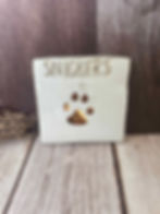 Off-white glazed square tile with gold filled paw print and text saying "Snickers"