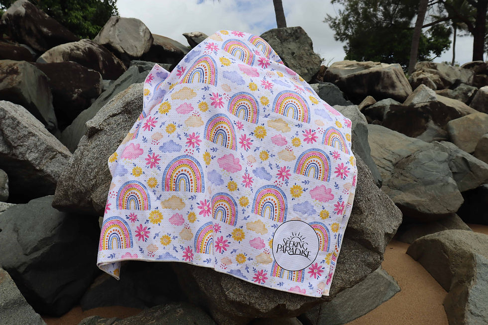Thumbnail: Rainbow microfibre towel draped over rocks.