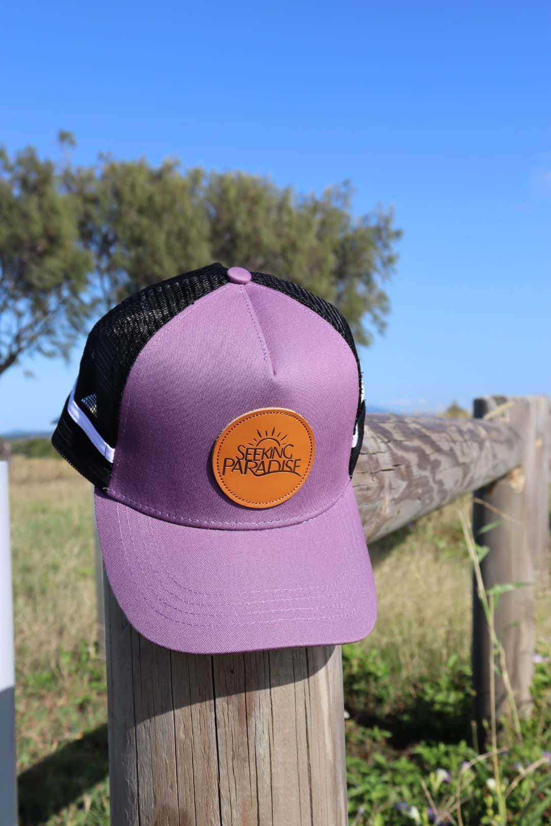 Purple trucker hat with black mesh panels, high and regular ponytail holes.