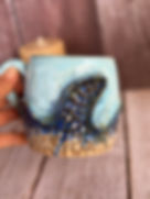 Textured mug in light blue, with dark blue wave and beige sand etched details