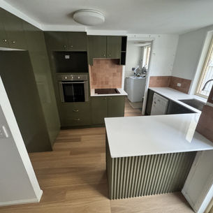 Olive green kitchen with white benchtops