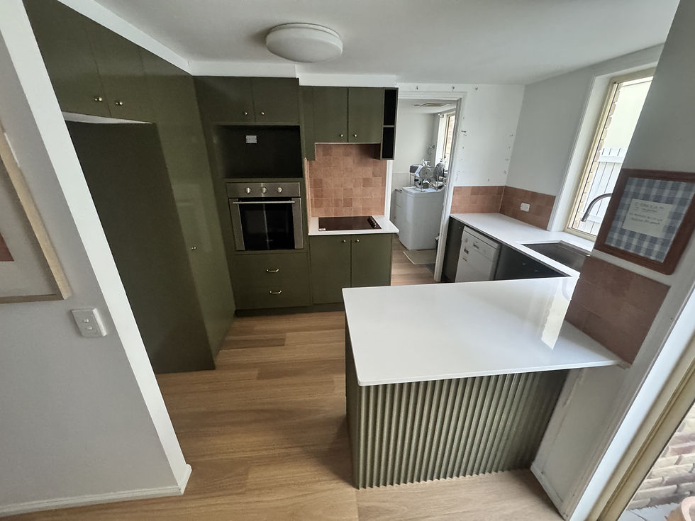 After resurfacing the kitchen is olive green with white benchtops and new flooring (external provider).