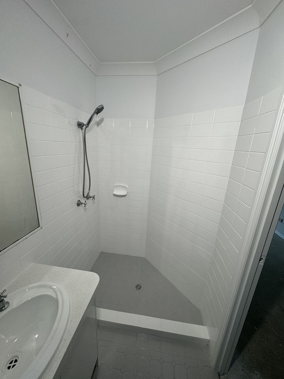 After resurfacing, the floor tiles are grey and the wall tiles look like a simple modern white.