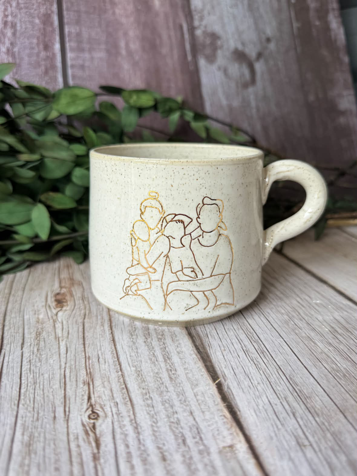White mug with personalised line art illustration of a family in gold