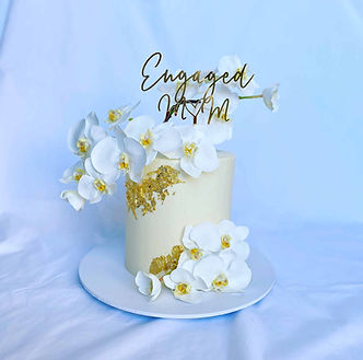 White Engagement Cake with gold leaf, orchids and gold cake topper