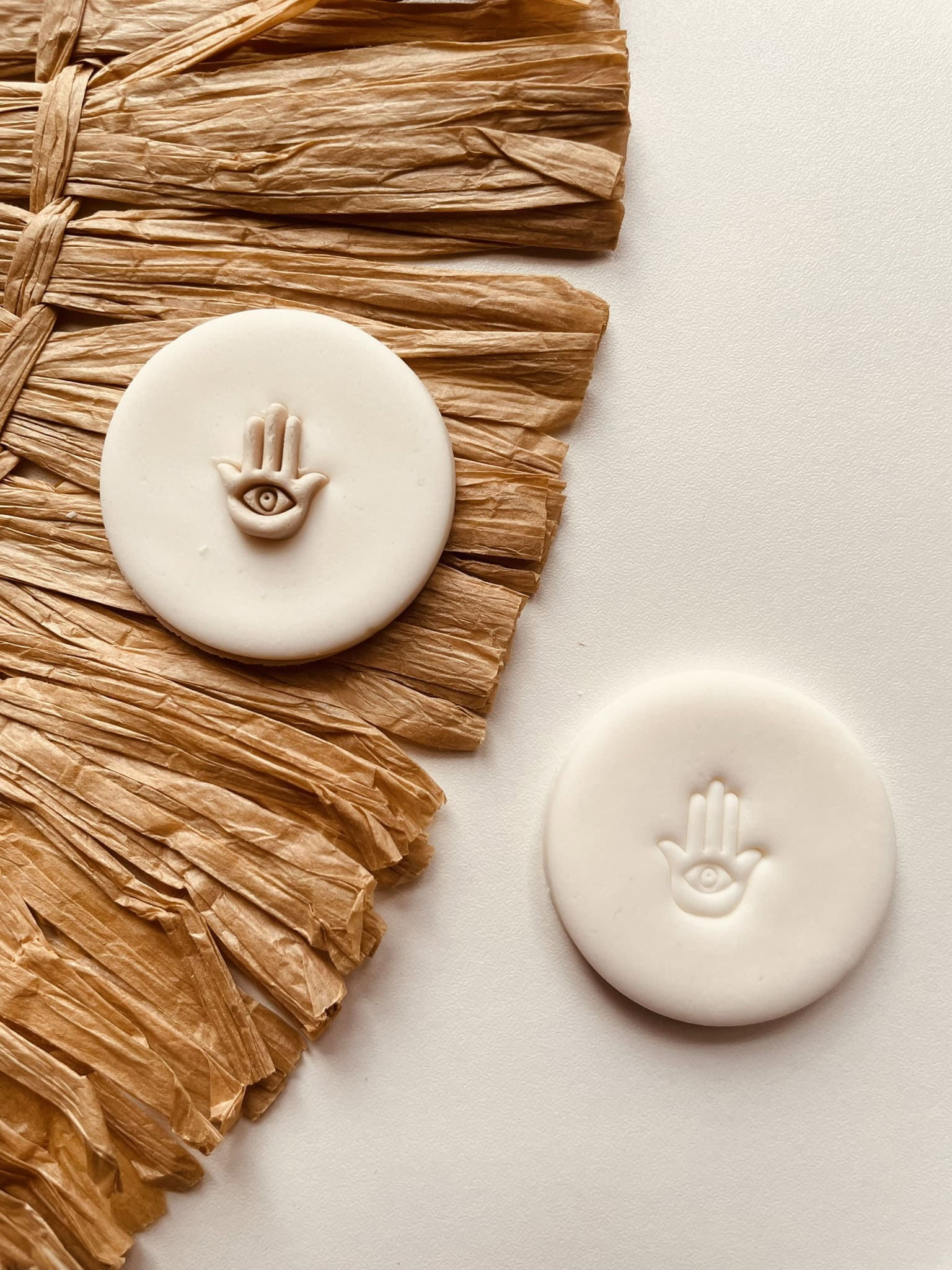 Mini hamsa cookie stamp shown in two-tone and single-tone fondant applications