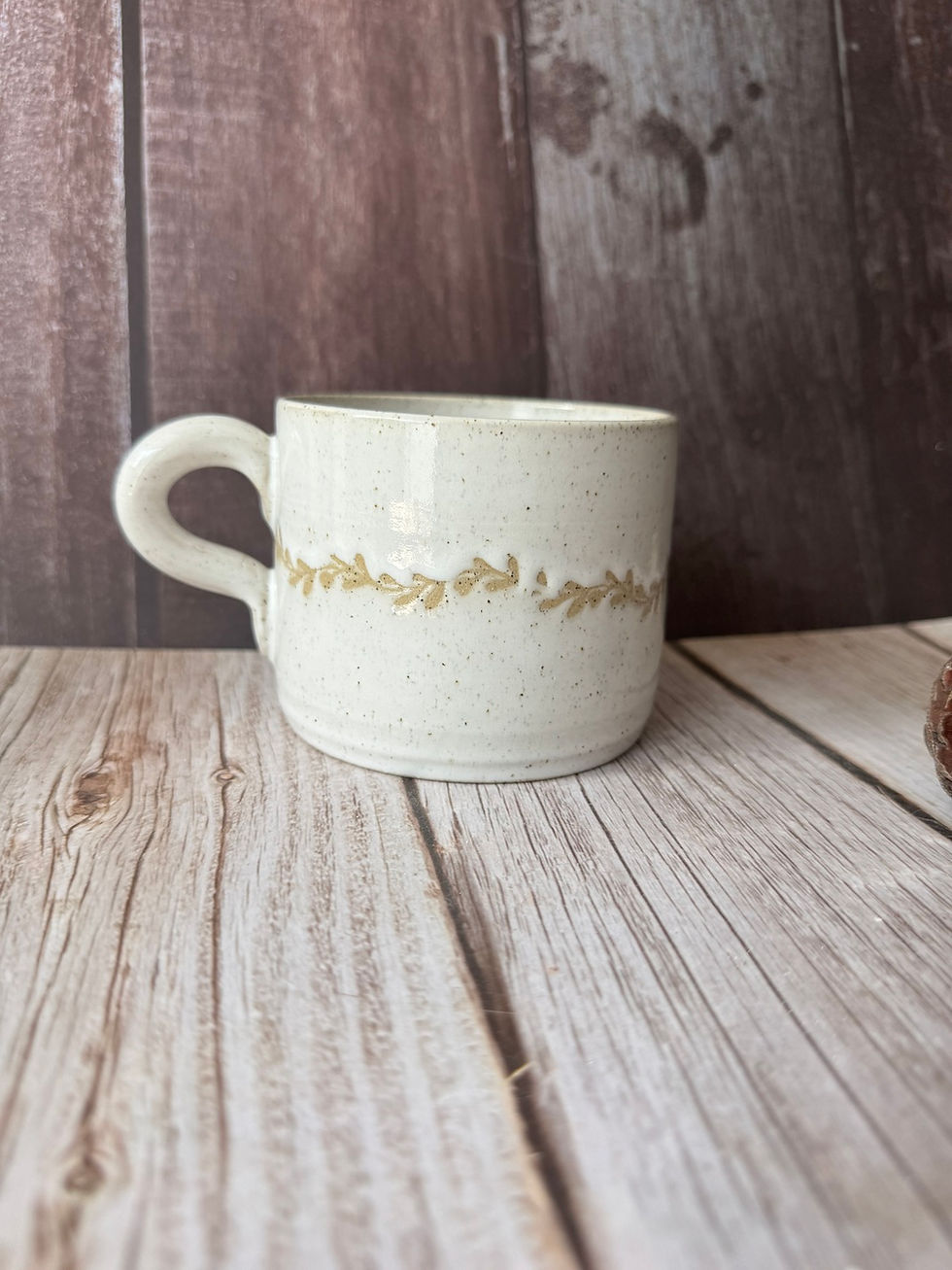 White ceramic mug with glaze-resist garland wrapping around the centre of the mug