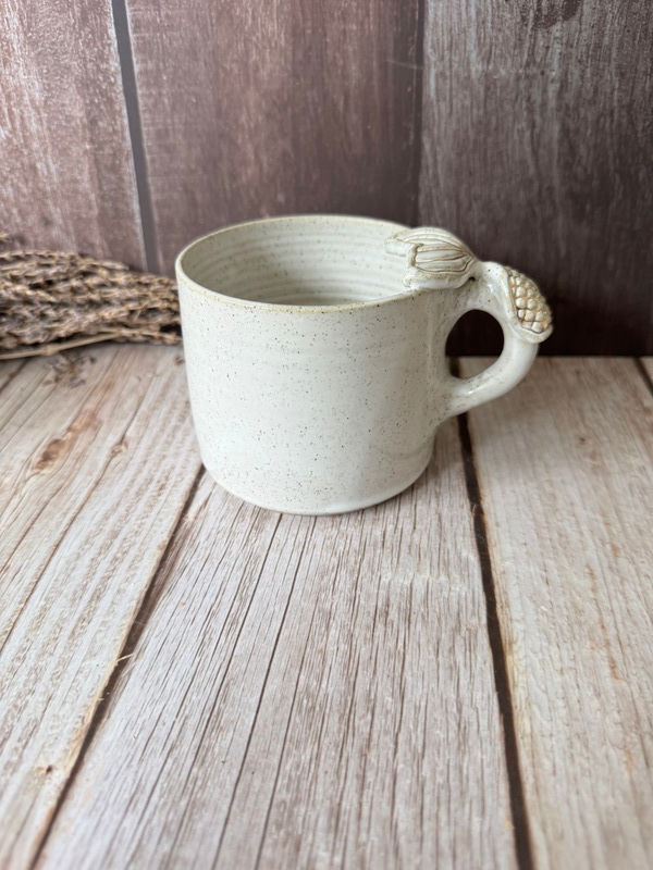 The front of the white mug with mermaid tail handle