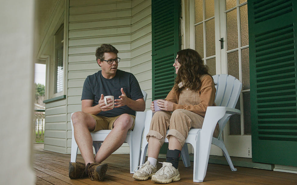Two people talking on a porch