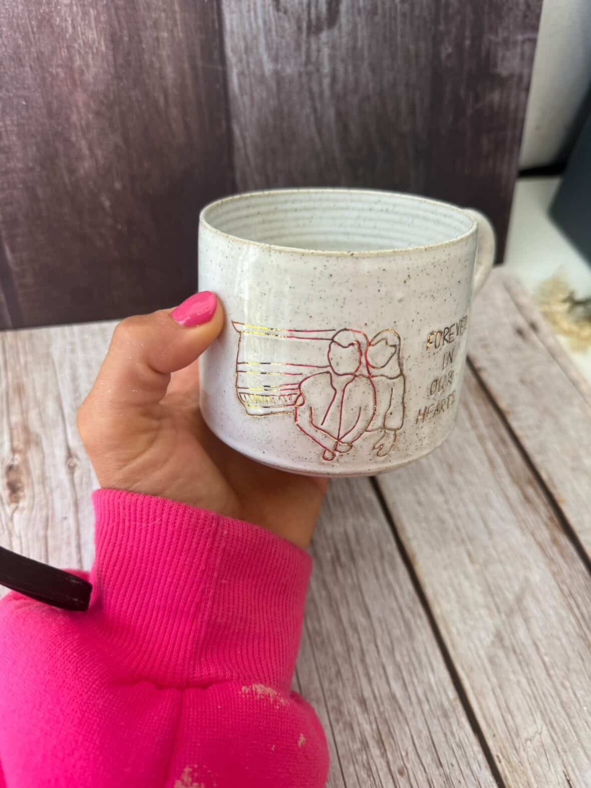 Pink sleeved hand holds a personalised line art mug