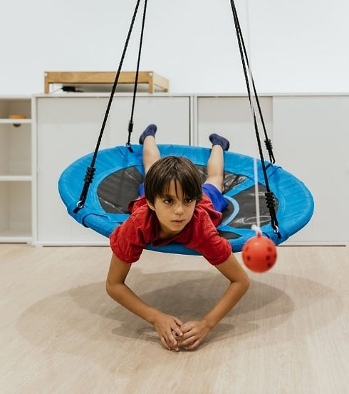 Child on indoor swing doing PBS
