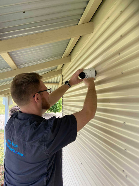 Matt installing a security camera on a wall