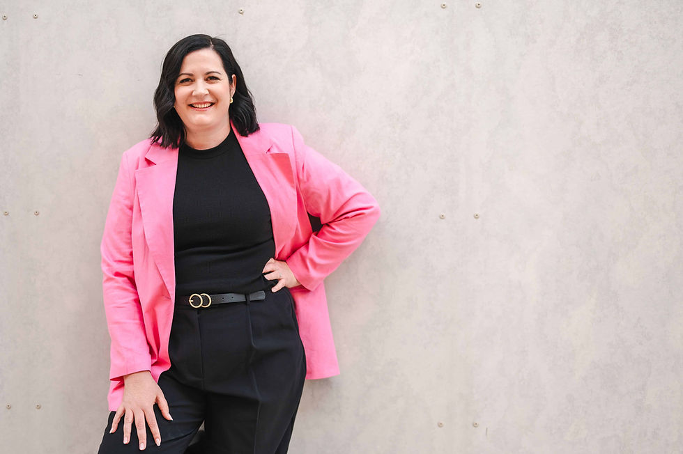 Candice, owner of Inspired Asset Finance, wearing black businesswear with a pink blazer